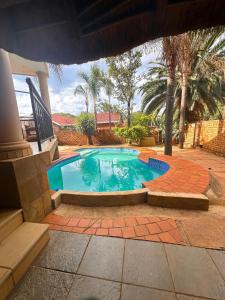 a swimming pool in a yard with a brick patio at Tsheryl's Guesthouse in Centurion