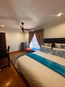 a bedroom with a large bed with a ceiling fan at Tsheryl's Guesthouse in Centurion