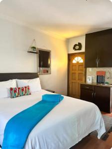 a bedroom with a large white bed with blue sheets at Tsheryl's Guesthouse in Centurion +7 photos