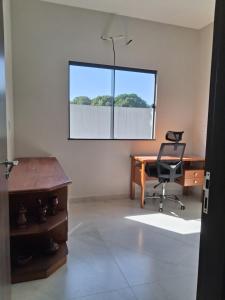 an office with a desk and a chair and a window at Casa em condomínio porto marina in Ananindeua