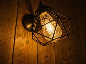 a lantern hanging on a wooden floor with a light at La Râu - Căsuța de poveste in Cîmpulung
