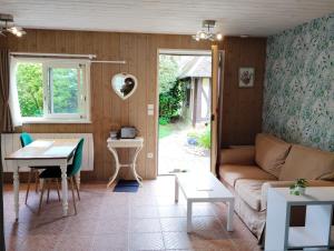 a living room with a couch and a table at Au p'tit jardin in Saint-Sylvestre-de-Cormeilles