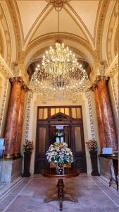 a large lobby with a chandelier and a vase of flowers at Noblesse Palace Old Town by NF in Bucharest +39 photos