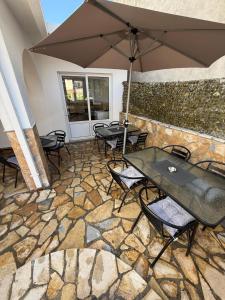 a patio with tables and chairs and an umbrella at Apartments Lazo in Ulcinj +5 photos