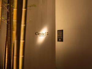 ein Schild an der Seite einer Wand mit einem Schild darauf in der Unterkunft CUVEE J2 HOTEL OSAKA by Onko Chishin in Osaka