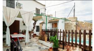 ein Haus mit einem Zaun neben einem Pool in der Unterkunft Casa rural El Parral in Bedmar