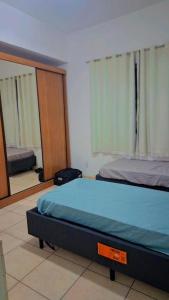 ein Schlafzimmer mit einem Bett und einem Spiegel in der Unterkunft Casa Vila Santa Cecília - No Centro da Cidade in Volta Redonda + 4 Fotos