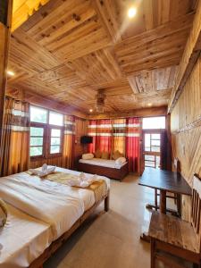 a bedroom with a large bed in a room with wooden ceilings at Wood Heaven Farms in Shimla