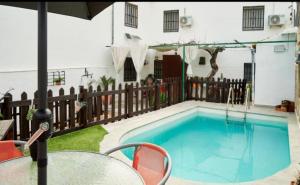 einen Pool mit einem Tisch und Stühlen neben einem Haus in der Unterkunft Casa rural El Parral in Bedmar