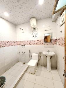 a bathroom with a toilet and a sink at Wood Heaven Farms in Shimla