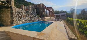 a swimming pool in front of a house at Korenishuli Veranda Wine Hotel 45 km from Tsageri in Tsʼageri