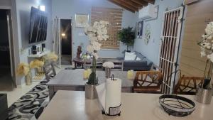 a living room with a table with flowers on it at 3CsMontego Bay in Montego Bay