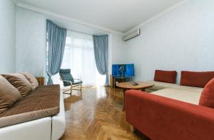una sala de estar con un sofá y una mesa en Apartment Arena City, en Kiev