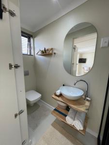 a bathroom with a sink and a mirror at Nahoon Studio A in East London +9 photos