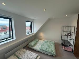 a bedroom with two beds and two windows at Kilby close in Edgware