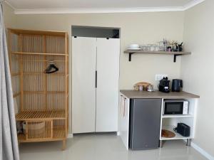 a kitchen with a refrigerator and a counter with a microwave at Nahoon Studio A in East London