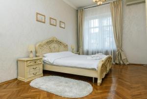 Un dormitorio con una cama y una cómoda y una ventana. en Apartment Arena City, en Kiev