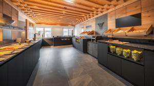 a large kitchen with black counters and tables in it at Waidringer Hof 4 Sterne Superior in Waidring