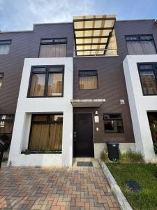 an apartment building with a black door and windows at House in Álika Club Residencial in Fraijanes