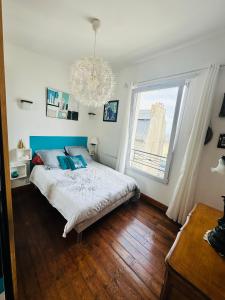 サン・ケ・ポルトリユーにあるAppartement vue merのベッドルーム1室(ベッド1台、窓、シャンデリア付)