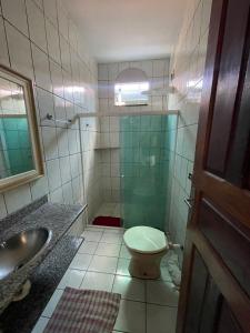 a bathroom with a toilet and a sink and a shower at Casa em Prado Bahia in Prado