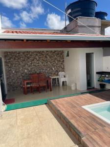 a patio with a table and chairs on a house at Casa em Prado Bahia in Prado