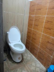 a bathroom with a white toilet in a tiled floor at Arlene's Homestay Siargao in General Luna