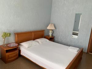 a bedroom with a bed and a table with a lamp at Ludmila guest house - гостевой дом "Людмила" in Odesa +13 photos