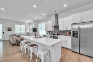 a kitchen with a large white counter and stools at 4BR Queen City Base Minutes to Stadium & NoDa in Charlotte