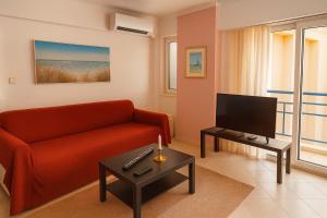 a living room with a red couch and a tv at Sea and Sky Infinity Blue Apartment in Gythio