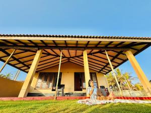a woman sitting on a blanket in front of a house at Sea Breeze Stay in Negombo