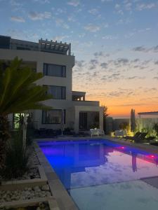 a villa with a swimming pool in front of a building at Suite Pool Golful Francez in Schitul