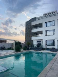 a building with a swimming pool in front of it at Suite Pool Golful Francez in Schitul