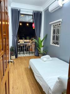 une chambre avec un lit et une salle à manger dans l'établissement The Little Ha Noi 5 Bedrooms Large Yard Balcony, à Hanoï