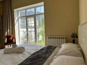 a bedroom with a large bed with a large window at Qafqaz Hills Villa in Gabala +22 photos