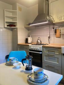 una cocina con fogones y una mesa con platos. en Wzgórze Czwartek, en Lublin