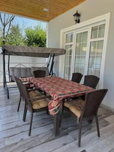 a table and chairs on a screened porch with a table and chairs at Qafqaz Hills Villa in Gabala