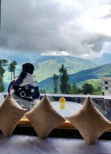 a person sitting at a table looking out a window at Wood Heaven Farms in Shimla