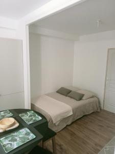 a small bedroom with a bed and two tables at Studio cosy et équipé in Caen