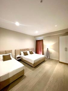 a hotel room with two beds and a window at Solea Hotel in Vlorë