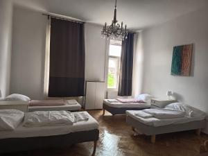 a room with three beds and a chandelier at Klauzál Apartman in Budapest
