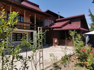 a house with a garden in front of it at Casa de vacanta 1001 De Nopti in Corbşori