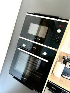 eine schwarze Mikrowelle auf einer Wand in der Unterkunft Évasion Marine- plage à 5 minutes a pied in Le Portel