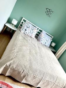 ein Schlafzimmer mit einem Bett mit einer weißen Bettdecke und Kissen in der Unterkunft Évasion Marine- plage à 5 minutes a pied in Le Portel