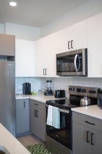 Casita Verde - 10' Domain - WiFi - Free Parking في أوستن: مطبخ بخزائن بيضاء وفرن موقد