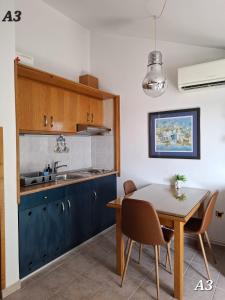 a kitchen with a dining room table and a sink at Apartments Oribella in Krk