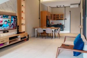 a living room with a dining room table and a tv at Griya Saka Magelang in Magelang