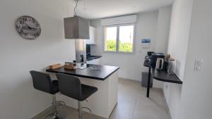 a kitchen with a table and chairs in a room at Cocon moderne avec terrasse a deux pas de locean in Saint-Brevin-les-Pins