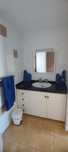 a bathroom with a sink and a toilet and a mirror at Bahía Meloneras in Meloneras