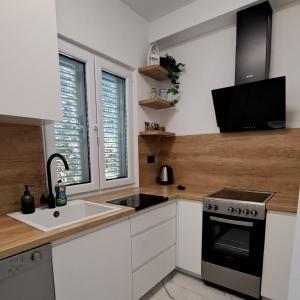a kitchen with a sink and a stove at Holiday home Blue 40 m from beach in Kruševo